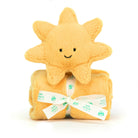 A yellow plush sun toy sits on a yellow blanket tied with a white ribbon.