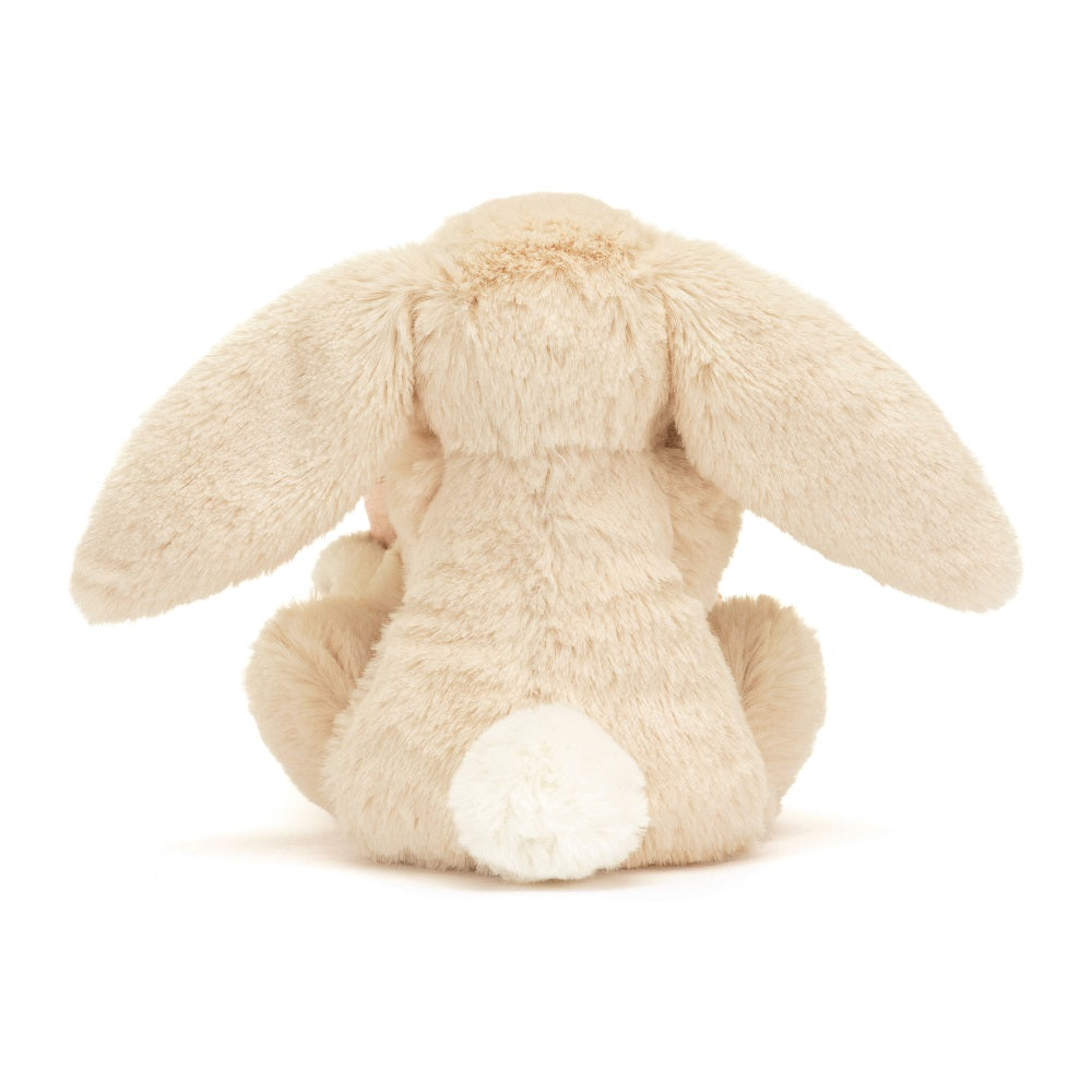 Back of tan stuffed rabbit with white tail.