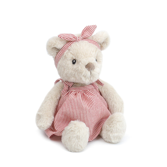 Stuffed teddy bear wearing a red and white striped dress and headband.