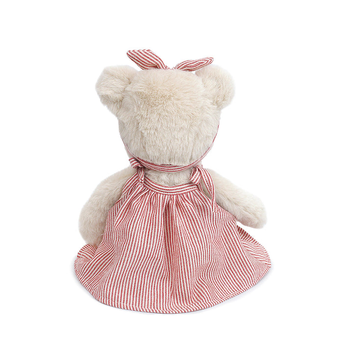 Rear view of a stuffed toy bear in a striped dress.
