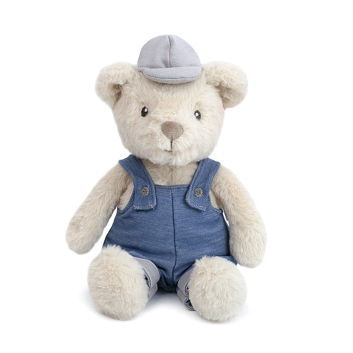 Teddy bear wearing denim overalls and a grey cap.