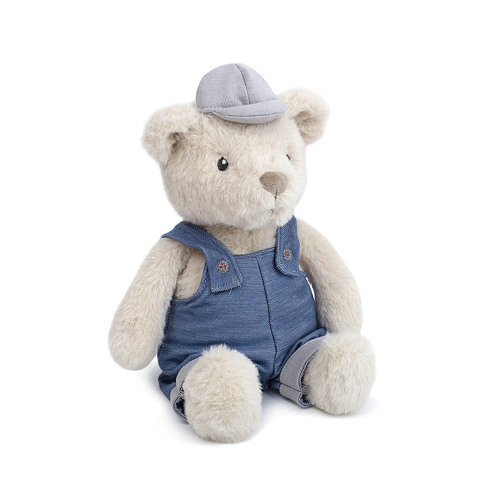 Stuffed teddy bear toy, blue denim overalls and gray cap.