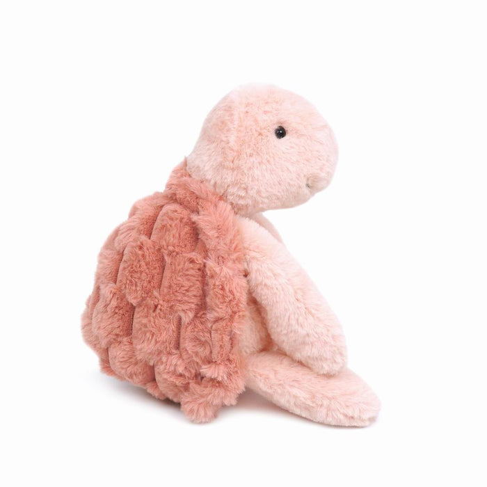 Pink plush turtle toy sitting.