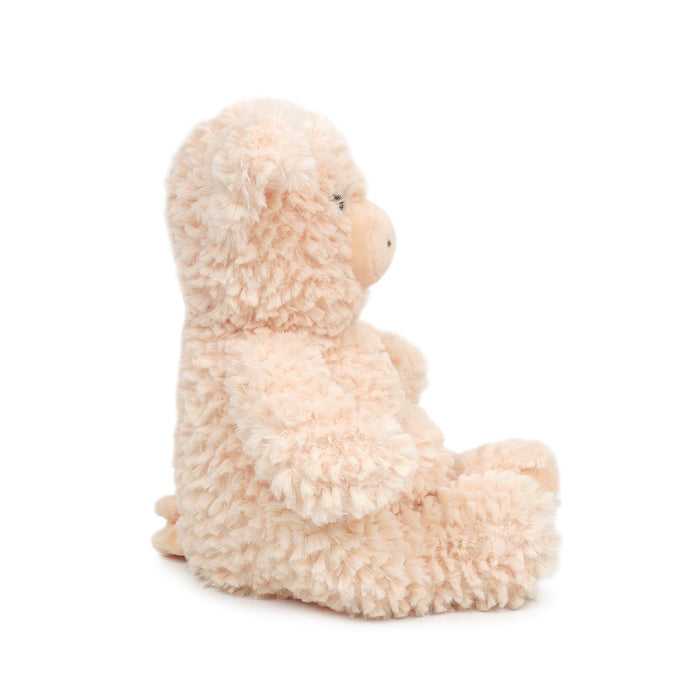 Fluffy peach-colored stuffed pig in a seated position.