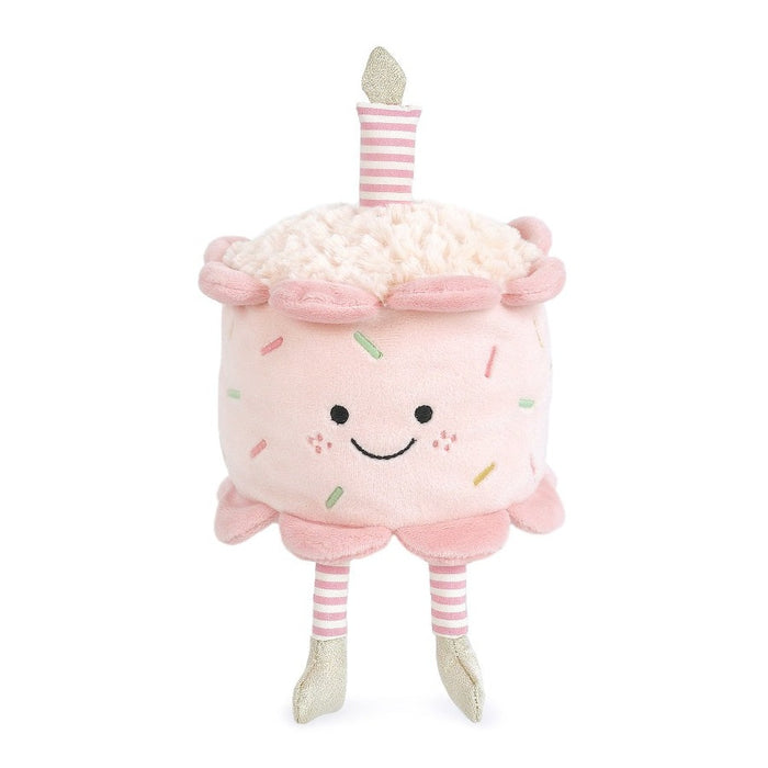A pink plush cupcake toy with a smiling face and a candle on top.
