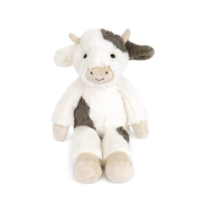 Stuffed cow toy in a sitting position. It has a white and brown color scheme with a stitched-on smile.