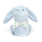 Blue plush bunny toy with a rolled blanket tied with a logo-printed ribbon.