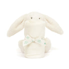 White bunny plush toy with rolled-up blanket, tied with a bow.