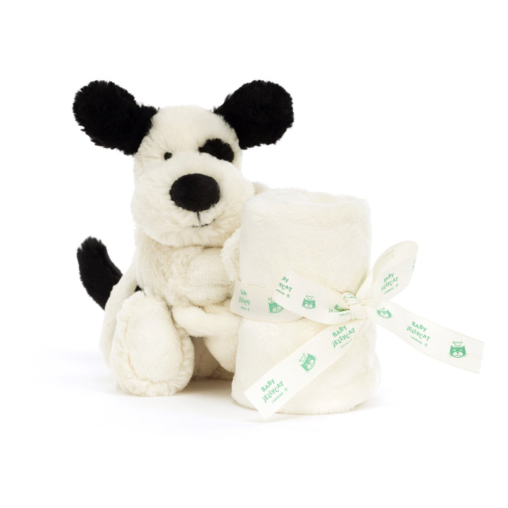 Stuffed dog with a cream-colored baby blanket wrapped in a bow.