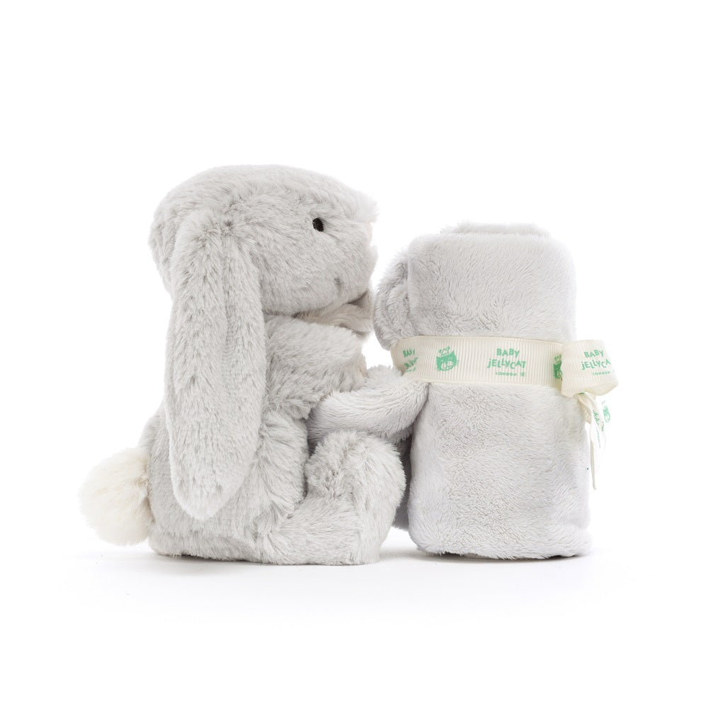 Grey plush bunny and rolled blanket.