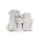 Grey plush bunny and rolled blanket.