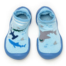 Two blue socks with rubber soles, patterned with sharks.
