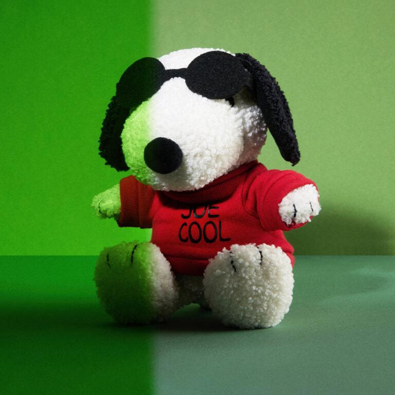Snoopy plush toy wearing sunglasses and a red "Joe Cool" shirt.