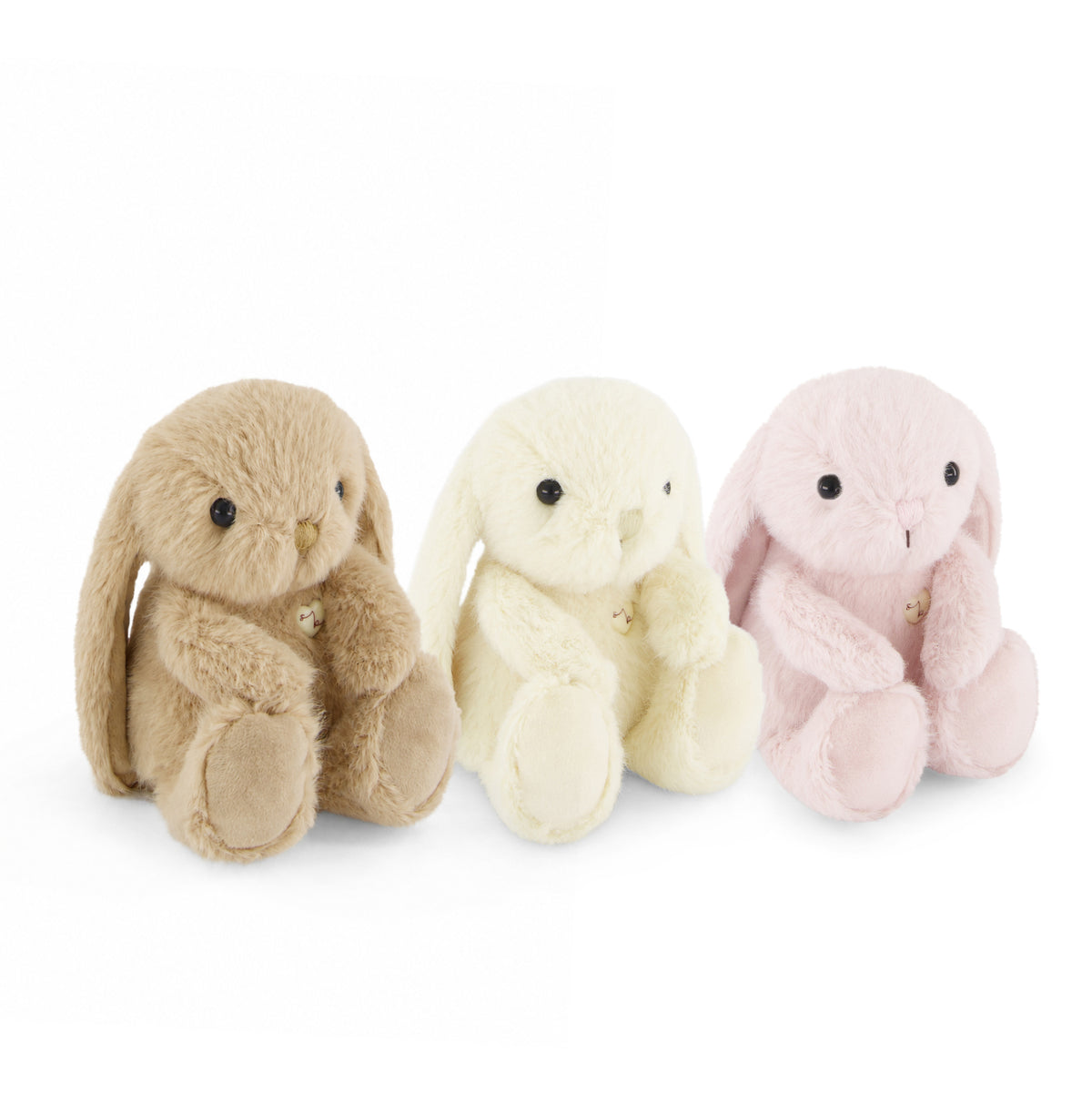 Three plush bunny toys in tan, cream, and light pink, arranged side by side on a plain white background.