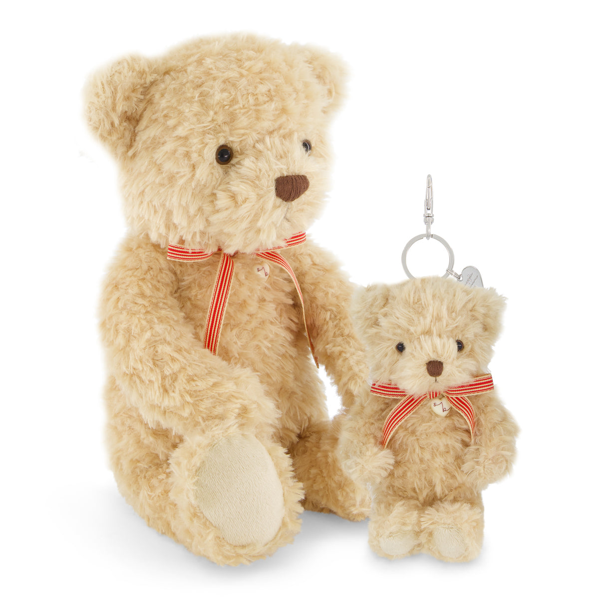 A large beige teddy bear plush toy with a red and white striped ribbon sits next to a smaller matching teddy bear keychain charm on a white background.
