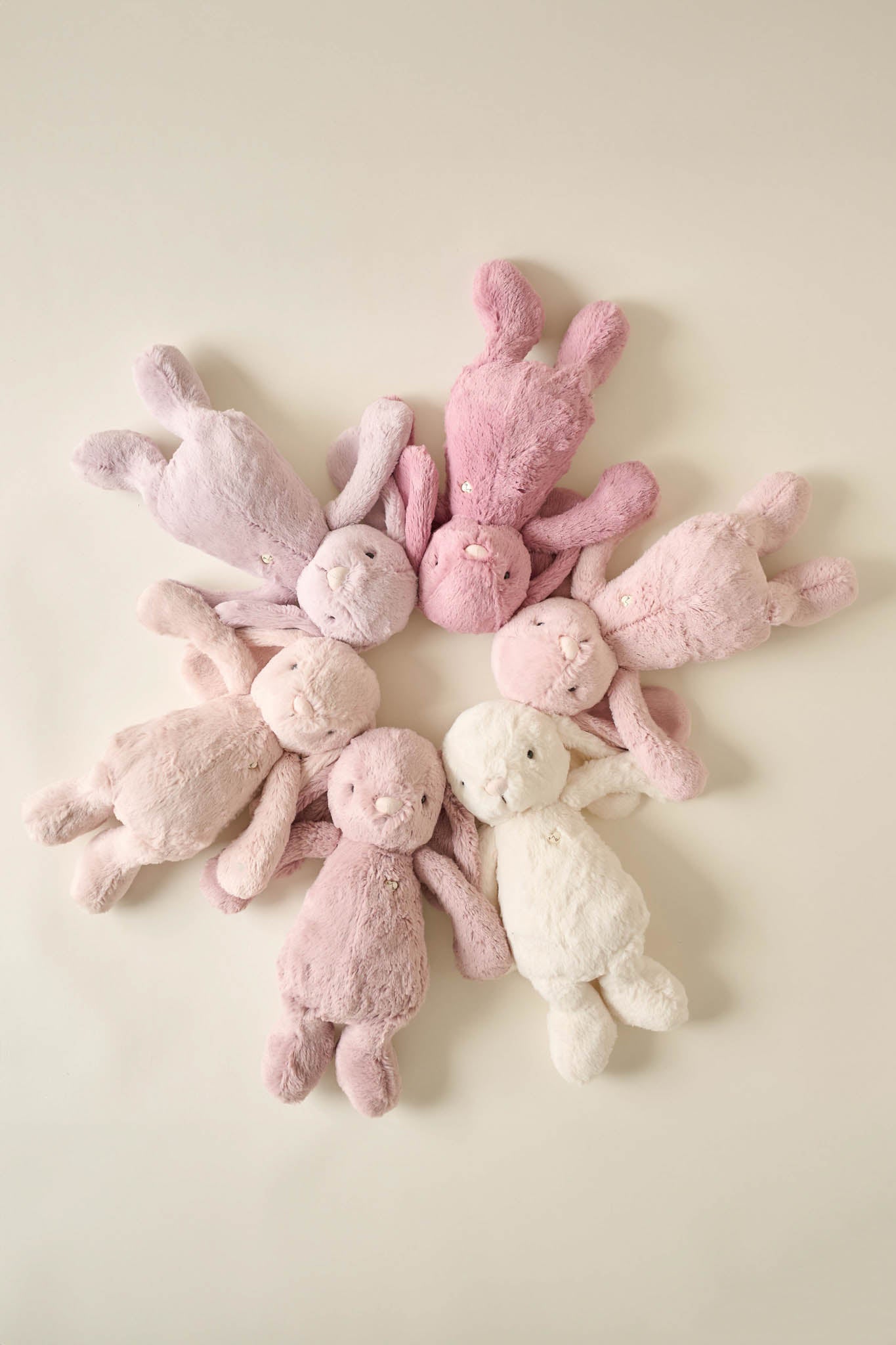 Eight plush bunny toys in a circular pattern.