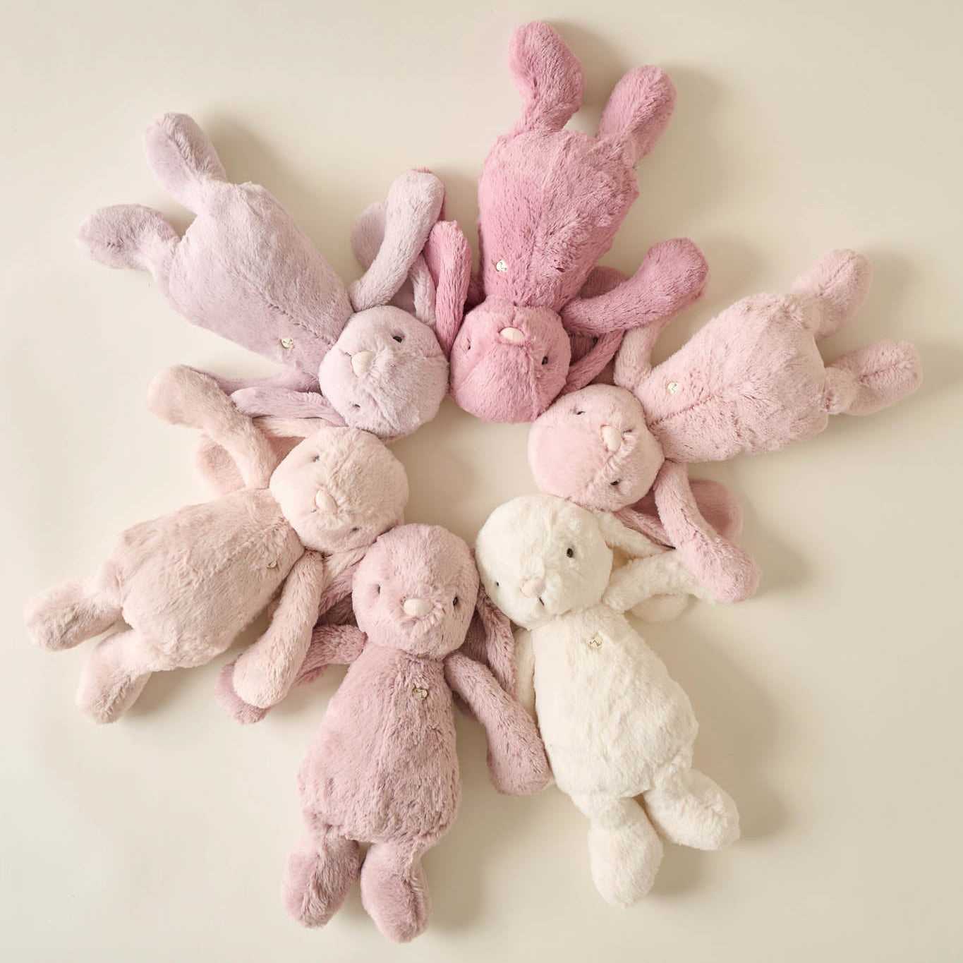 Eight plush bunny toys in a circular pattern.