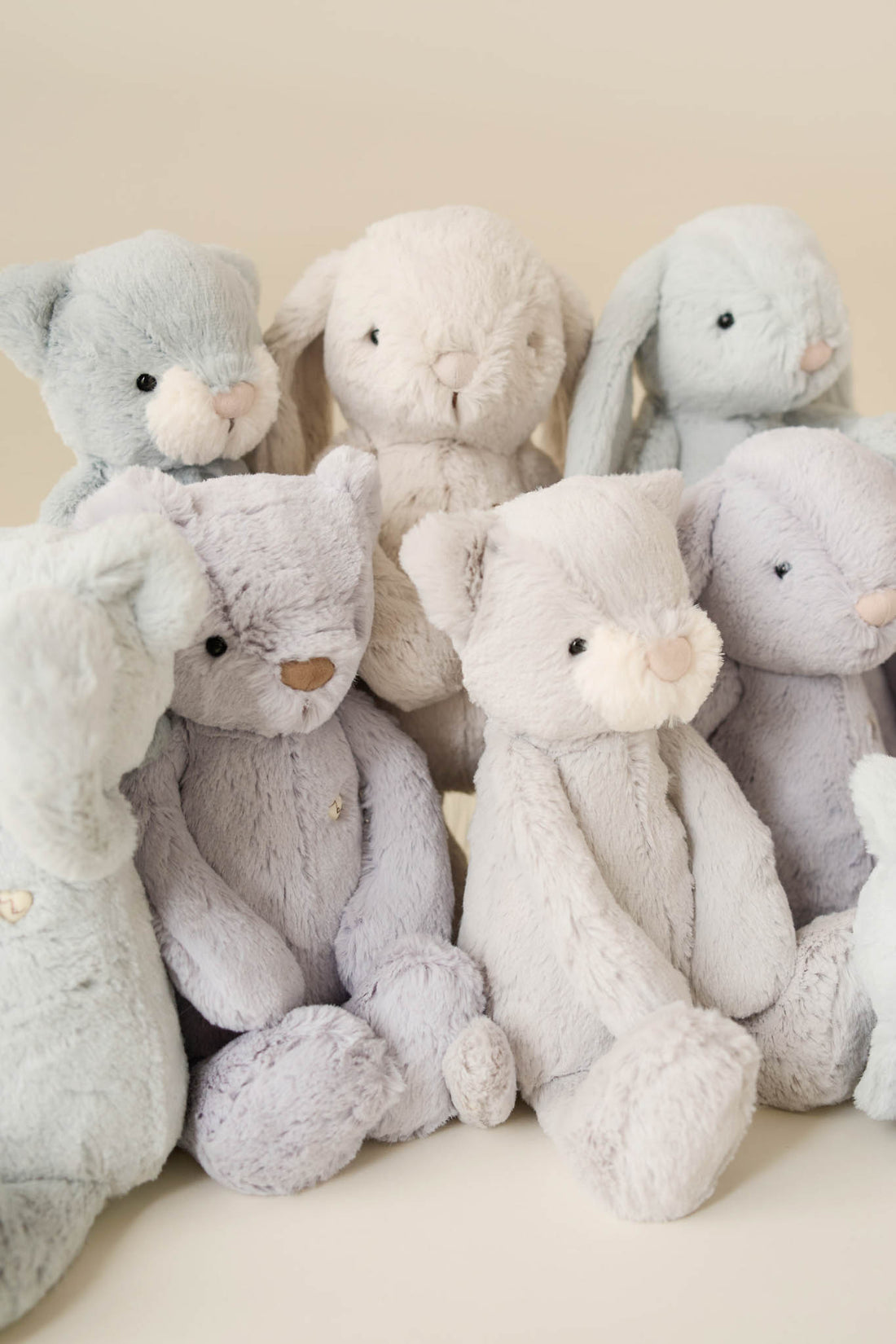 An assortment of plush bunny and bear toys in pastel colors.