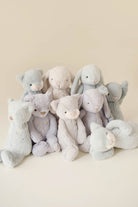 Group of plush teddy bears and bunnies in shades of grey and white.
