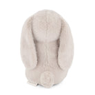 Back of a beige stuffed bunny with long ears and a fluffy tail.
