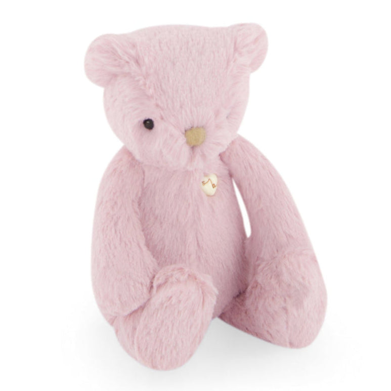 Pink teddy bear with a heart-shaped button.