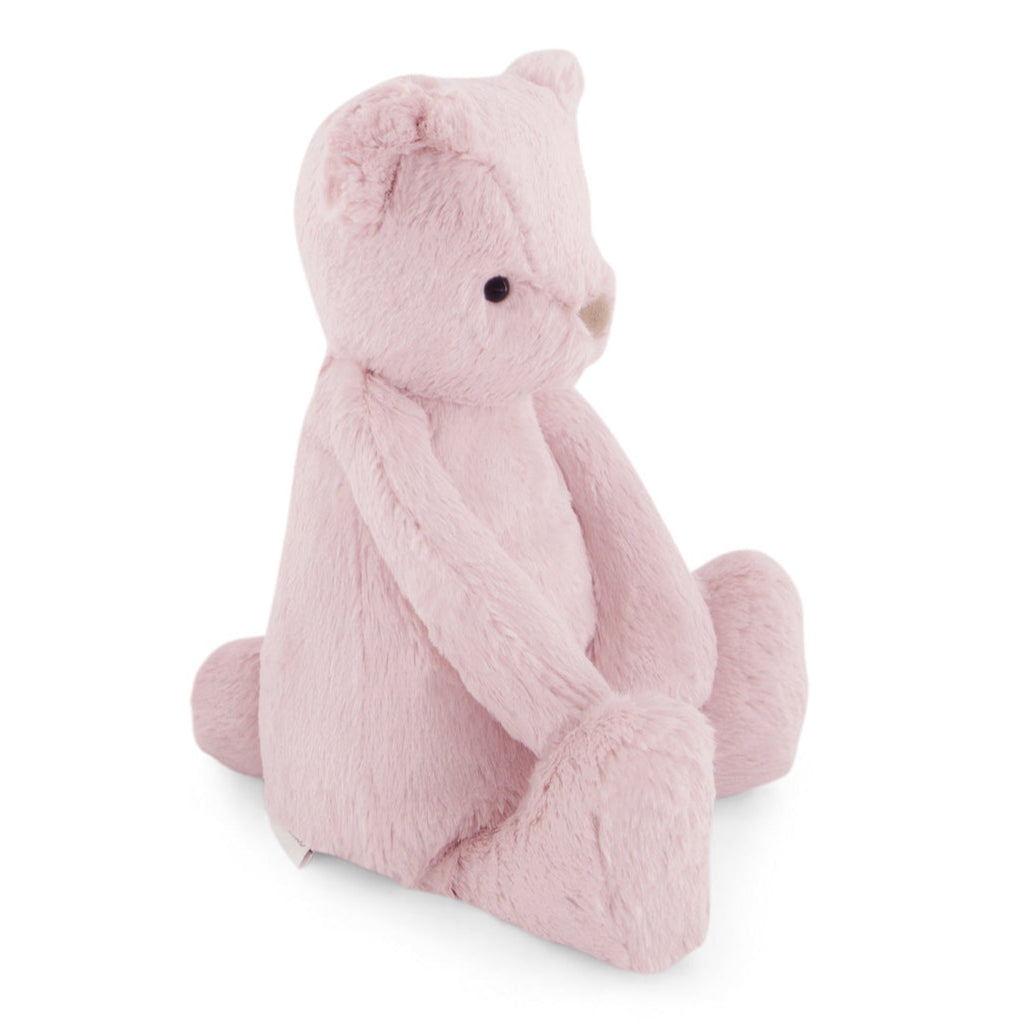 Pink plush teddy bear sitting.