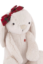 Cream-colored plush bunny with red plaid bow.