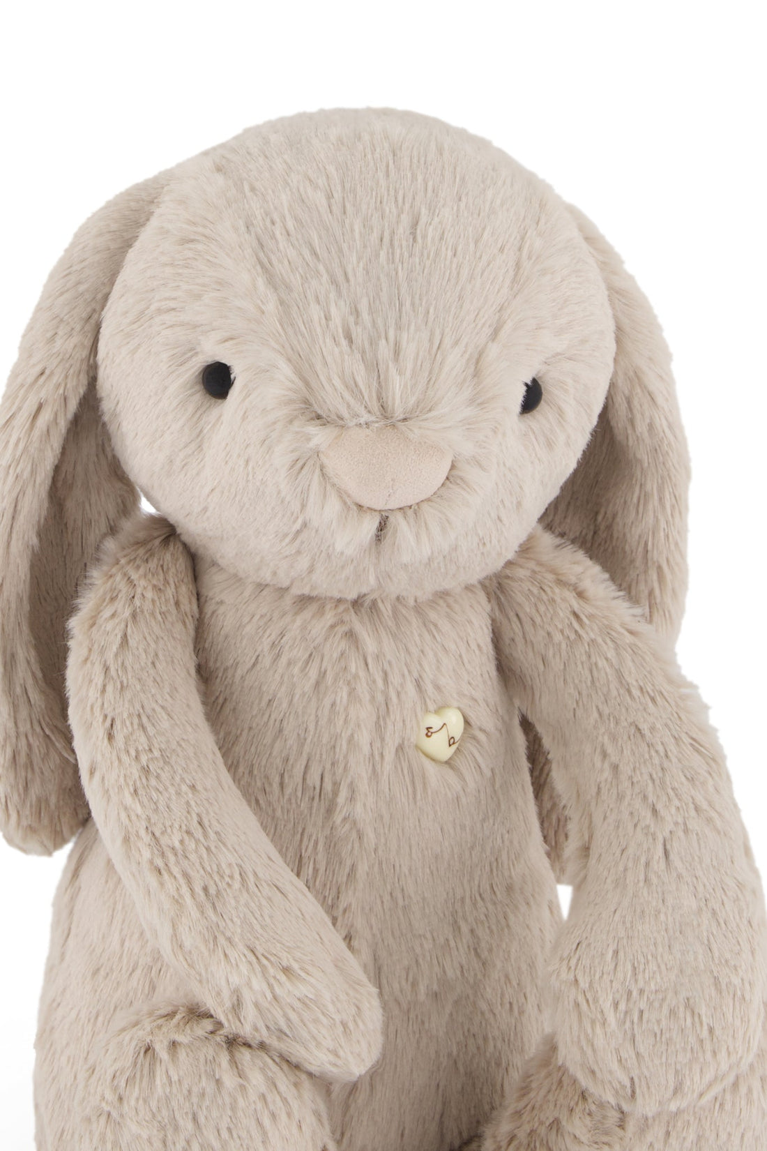 Stuffed bunny toy, beige plush fabric, heart-shaped button.