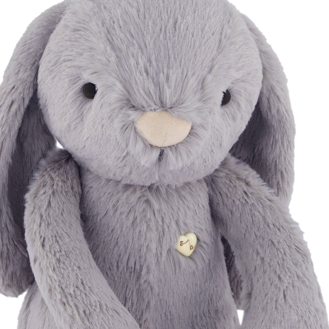 Grey plush bunny with a heart-shaped button.