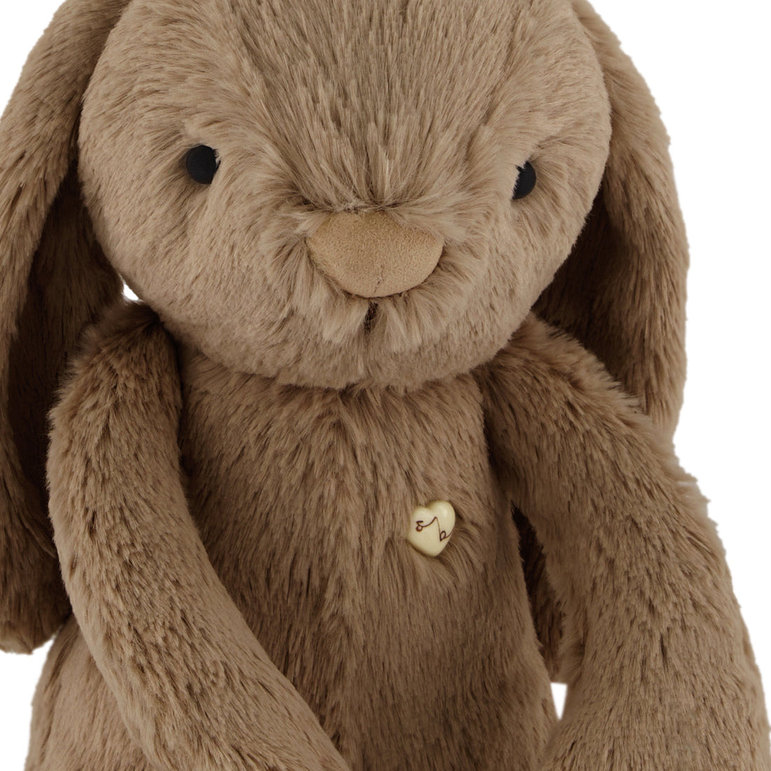 Brown plush bunny with a heart-shaped button.