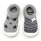 Two baby shoe socks, one with blue stars, the other with grey and blue stripes and a white star.