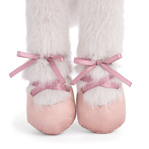 Pink ballet shoes with white fur and pink ribbons on a white background
