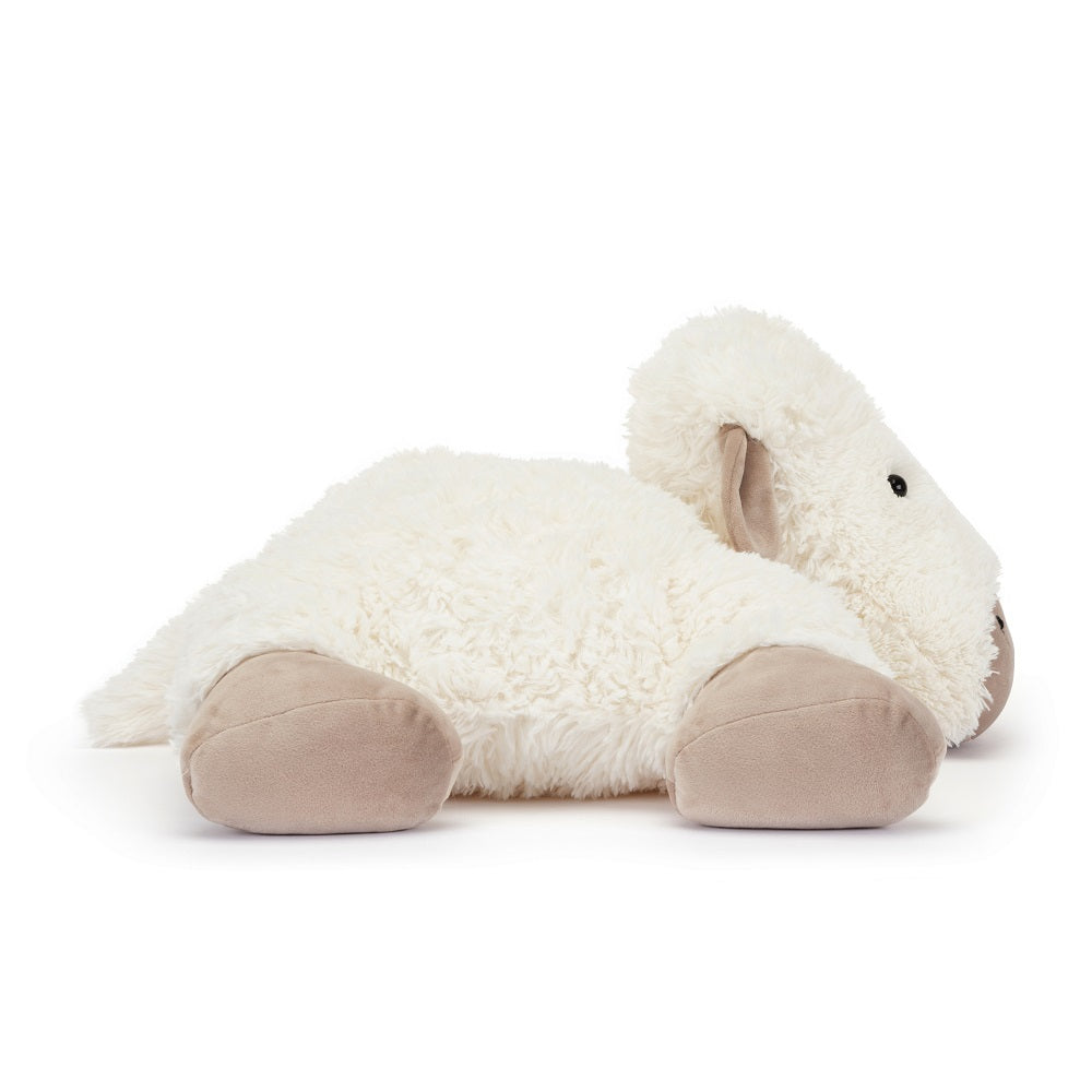 A plush, stuffed sheep toy laying down.