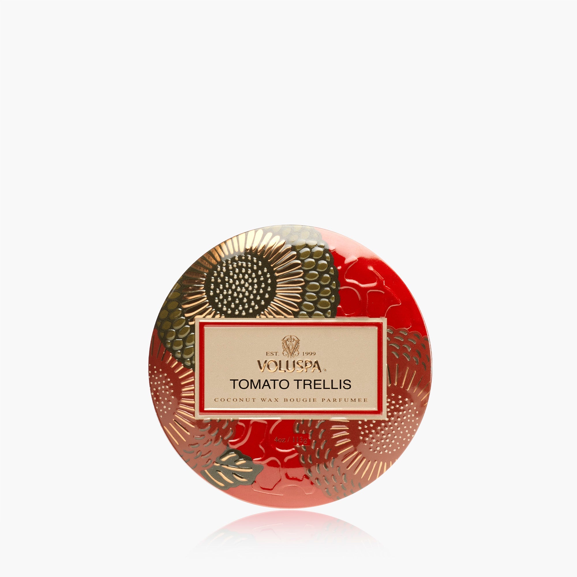 A round tin of Voluspa Tomato Trellis coconut wax body perfume, featuring a vibrant red background with metallic gold and olive green botanical patterns and a central cream-colored label.