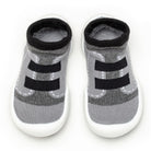 A pair of gray and black baby sock-shoes with white soles.