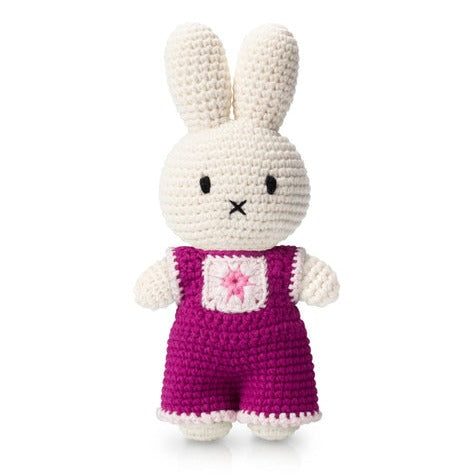 Crocheted Miffy doll wearing pink overalls.