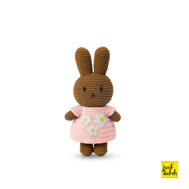 Crocheted brown bunny wearing a pink dress with white flowers.