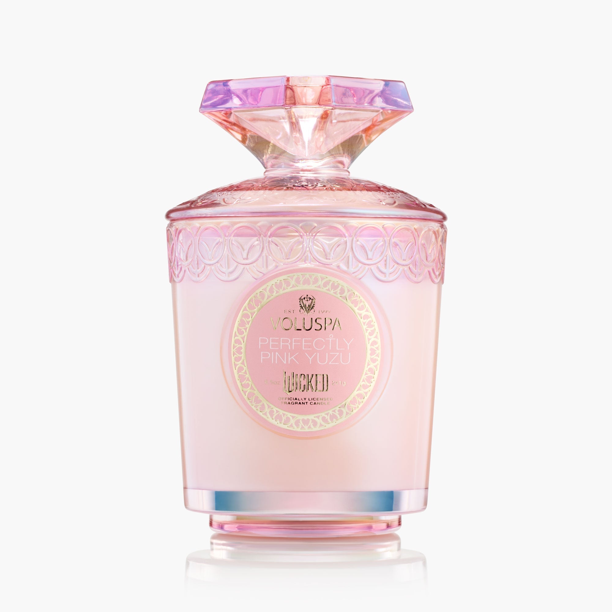 Pink perfume bottle with decorative cap on a white background