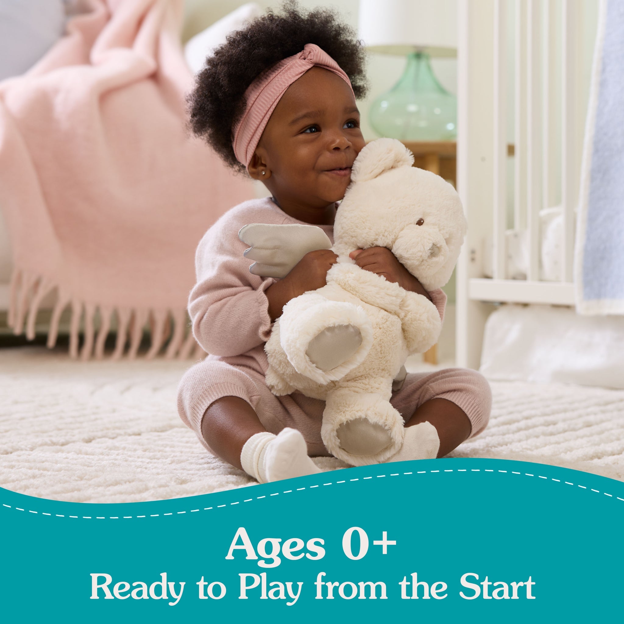 Baby hugging a teddy bear in a bedroom.