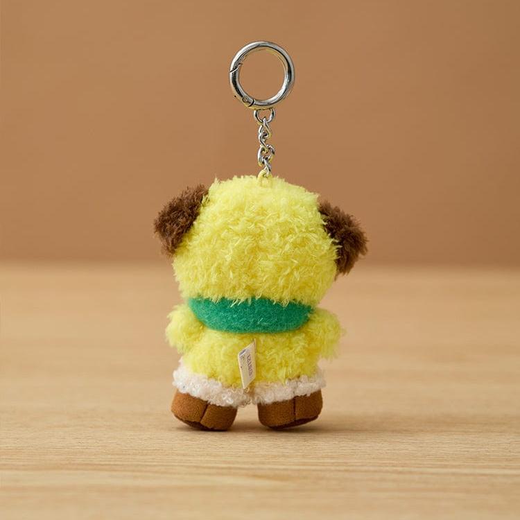 Yellow plush keychain with brown ears and a green scarf.