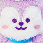 Close-up of a purple plush toy with a white bunny face featuring purple eyes and mouth, pink cheeks, and a blue collar.