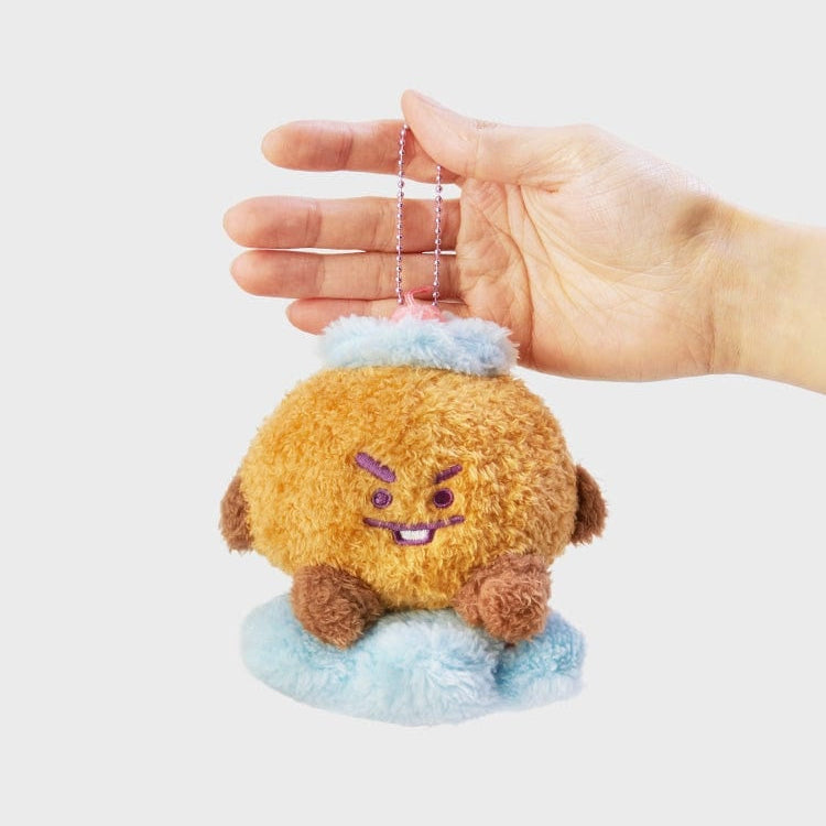 Plush brown character keychain toy held by a hand.