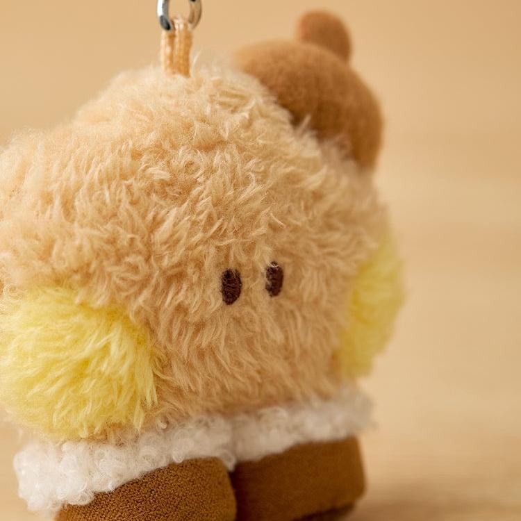 Close-up of a tan and yellow fuzzy plush toy with brown shoes and a white fluffy trim.