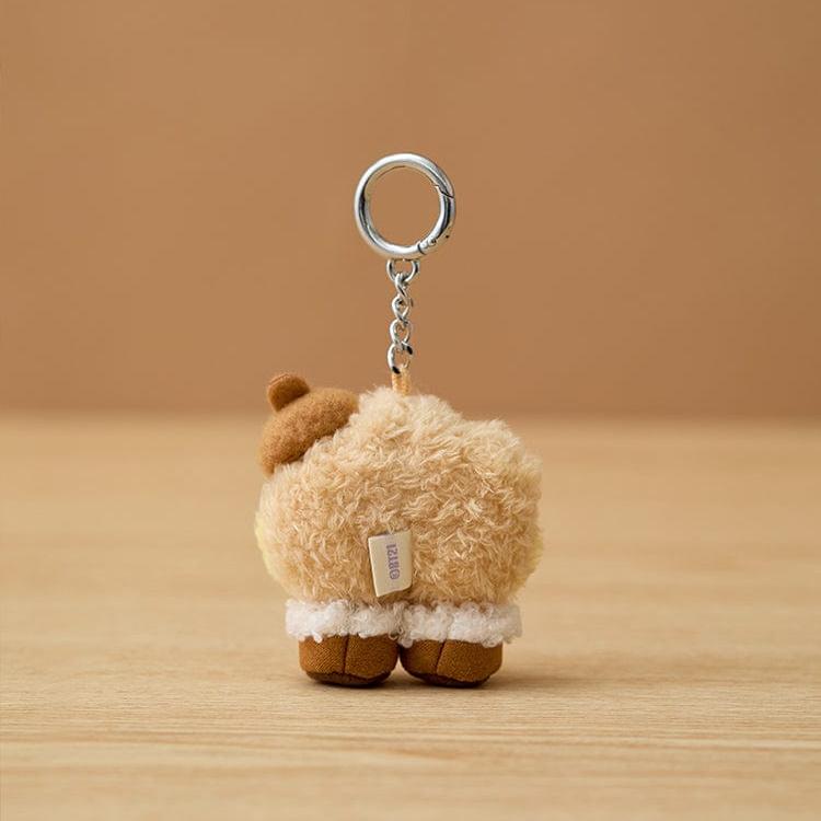 A fluffy, beige BT21 sheep keychain.