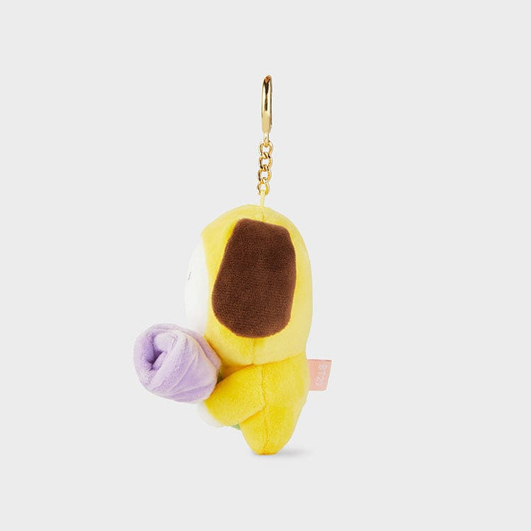 Yellow plush toy keychain with brown ear and purple flower.