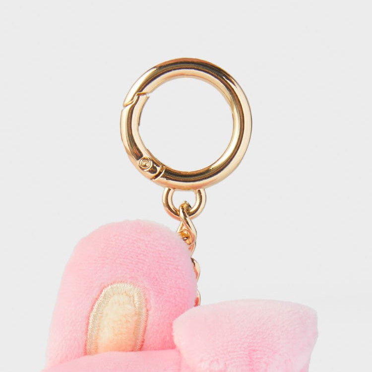 Close-up of a pink plush keychain with a gold-colored clip.