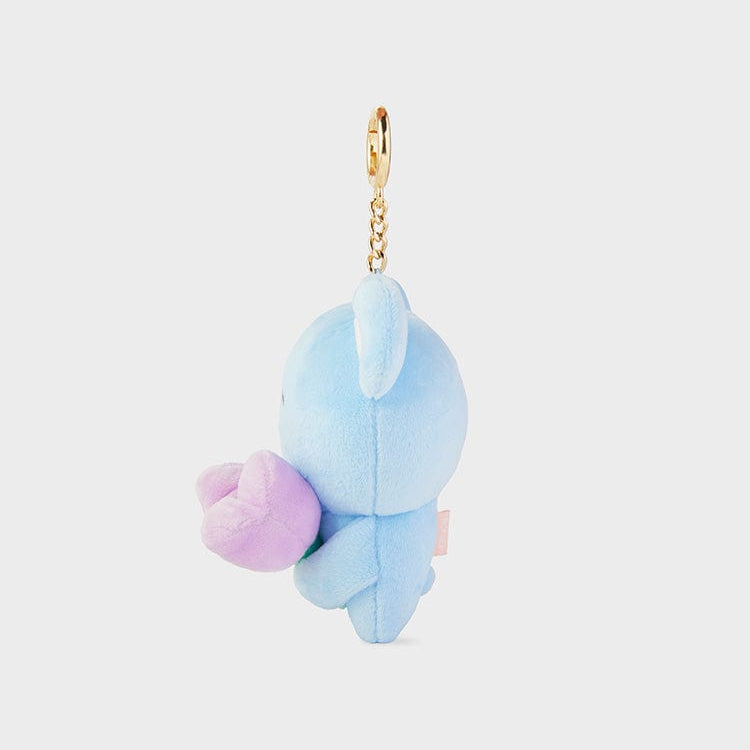 A light blue, plush, cartoon animal keychain with a golden clasp and a purple heart.