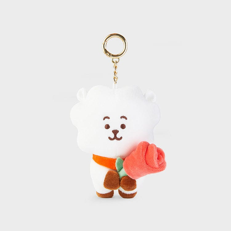 White plush toy keychain with orange scarf and pink rose.