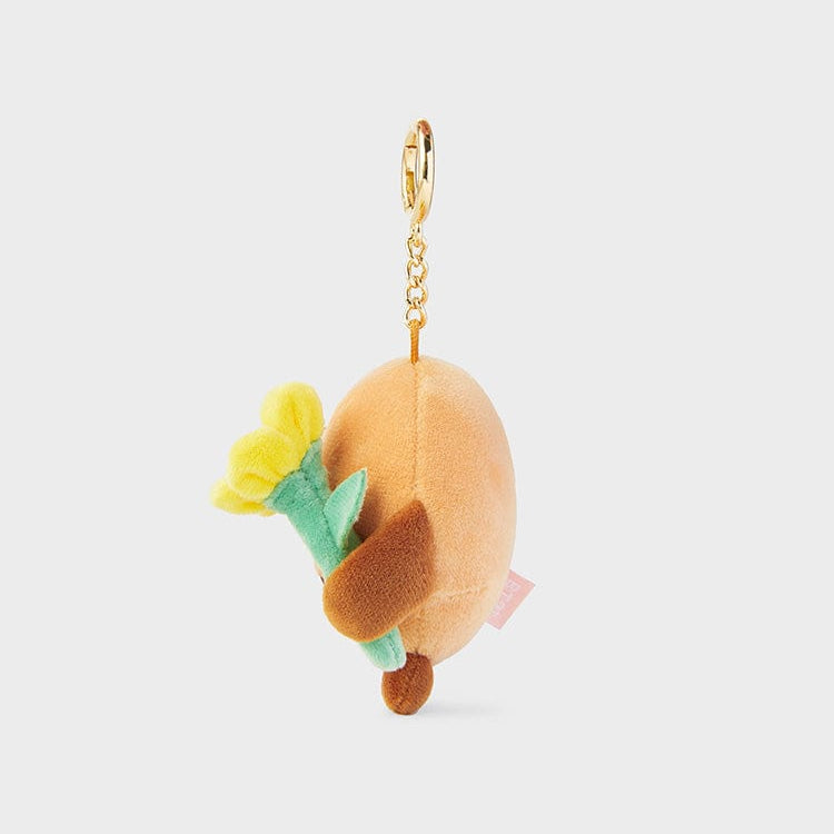 Brown and tan plush keychain holding a yellow flower.