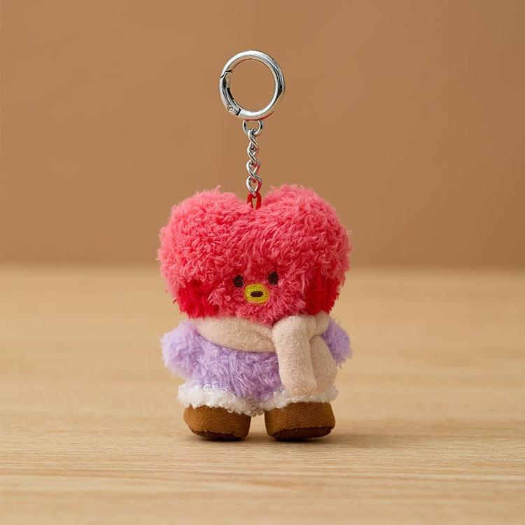 Front-facing, pink, fuzzy BT21 Tata plush keychain with a purple jacket and cream scarf.